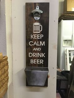 a wooden sign that says keep calm and drink beer hanging on the wall in a kitchen