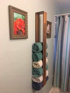 towels are stacked up on a towel rack in the bathroom