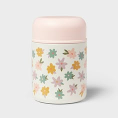 a pink and white container with colorful flowers on the front, sitting against a gray background