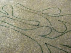 a close up view of a carpet with the word love written in green ink on it