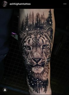 a black and white tattoo on the leg of a man with a snow leopard head