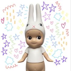 a small toy rabbit is standing in front of colorful stars