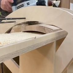 a person using a circular saw to cut some wood with a machine in the background