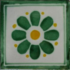 a green and white tile with an orange center