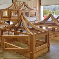 several wooden beds sitting on top of a floor next to each other in a room