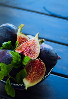 figs and greens in a bowl on a wooden table