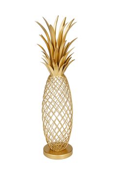 a gold pineapple on a stand against a white background