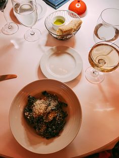 a table topped with plates and glasses of wine