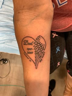 a person with a tattoo on their arm that has a heart and wings in it