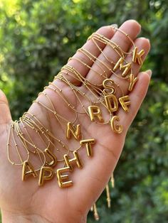 a person holding out their hand with gold letters on it