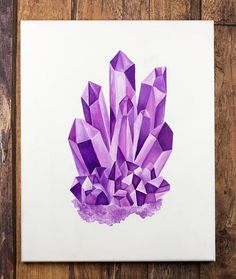 a piece of art that is on a wooden table and has purple crystals painted on it