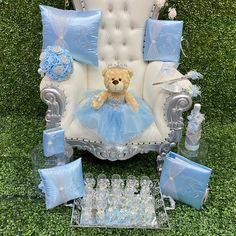 a teddy bear is sitting on a chair with blue pillows and other items around it