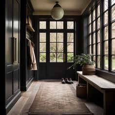 a hallway with black walls and wooden floors has a rug on the floor next to it