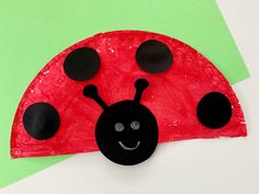 a paper plate with a ladybug on it and some black dots around the eyes