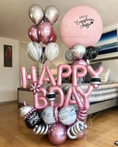 a bunch of balloons that say happy bday in the middle of a living room