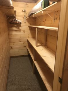 the inside of a small wooden cabin with bunk beds on each side and shelves below