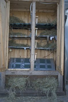 an open wooden box with hay and other items in it's back compartment,