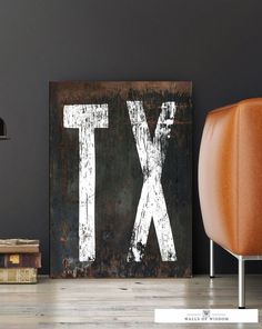 an old rusty metal sign with the letter tx on it next to a leather chair