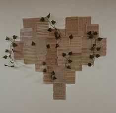 a sculpture made out of old book pages with ivys growing on it's sides