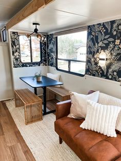 a couch and table in a room with blue floral wallpaper on the walls behind it