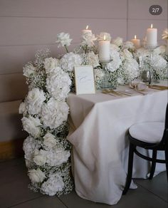 the table is set with white flowers and candles