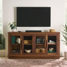 a living room with a large flat screen tv mounted on the wall next to a green chair