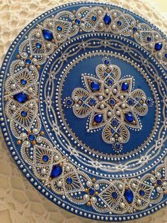 a blue and white plate sitting on top of a doily