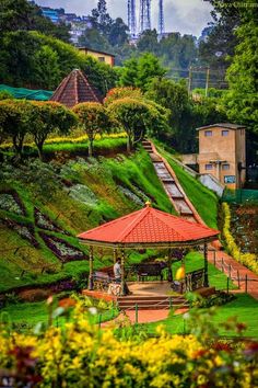 a red gazebo sitting on top of a lush green hillside