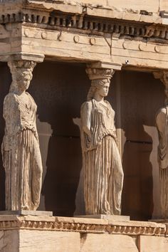 three statues on the side of a building