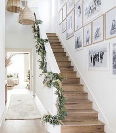 the stairs are decorated with greenery and pictures on the wall