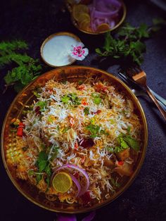 a bowl filled with rice and vegetables on top of a table next to utensils