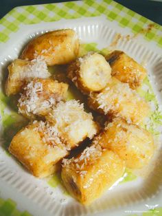 a white plate topped with bananas covered in grated cheese