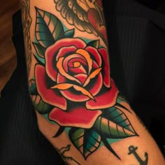 a rose and anchor tattoo on the arm