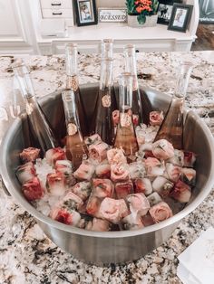 a metal bowl filled with lots of ice and wine bottles