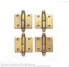 four brass - plated door hinges on a white background