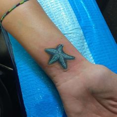 a small starfish tattoo on the wrist