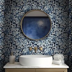 a white sink sitting under a round mirror