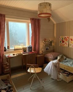 a child's bedroom with two beds and a desk in front of the window