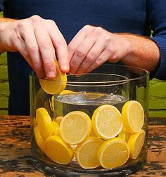 someone is squeezing lemons into a glass bowl