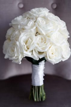 a bouquet of white roses sitting on top of a chair