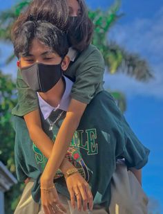 a young boy wearing a face mask is being hugged by his friend