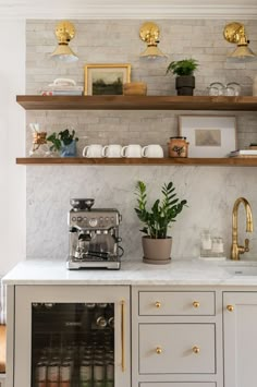 a kitchen with marble counter tops and shelves filled with pots, plants and coffee machines