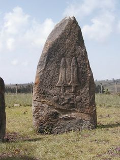 two large rocks with carvings on them in the grass