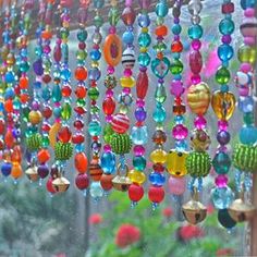 colorful beads hanging from a window in the rain