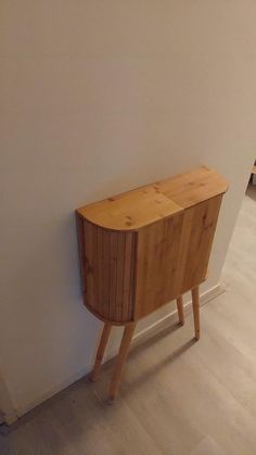 a small wooden cabinet sitting against a wall