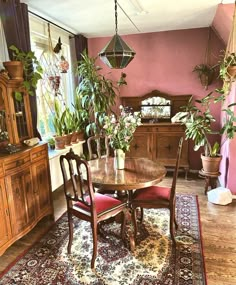 a dining room table and chairs with plants in vases on top of the table