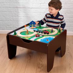 a young boy playing with a toy train set