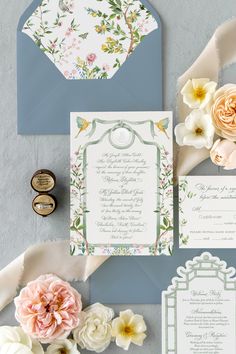 the wedding stationery is laid out with flowers