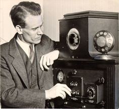 a man in a suit is looking at an old fashioned radio