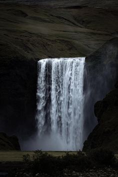 a large waterfall in the middle of a field